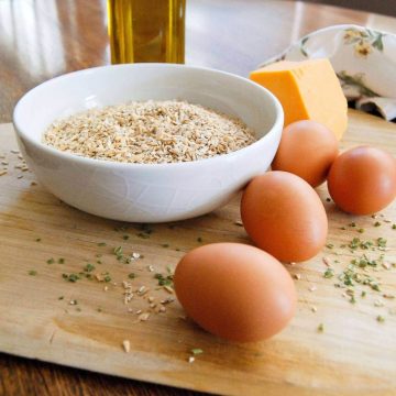 Savory steel cut oats in bowl with egg, cheese and herbs