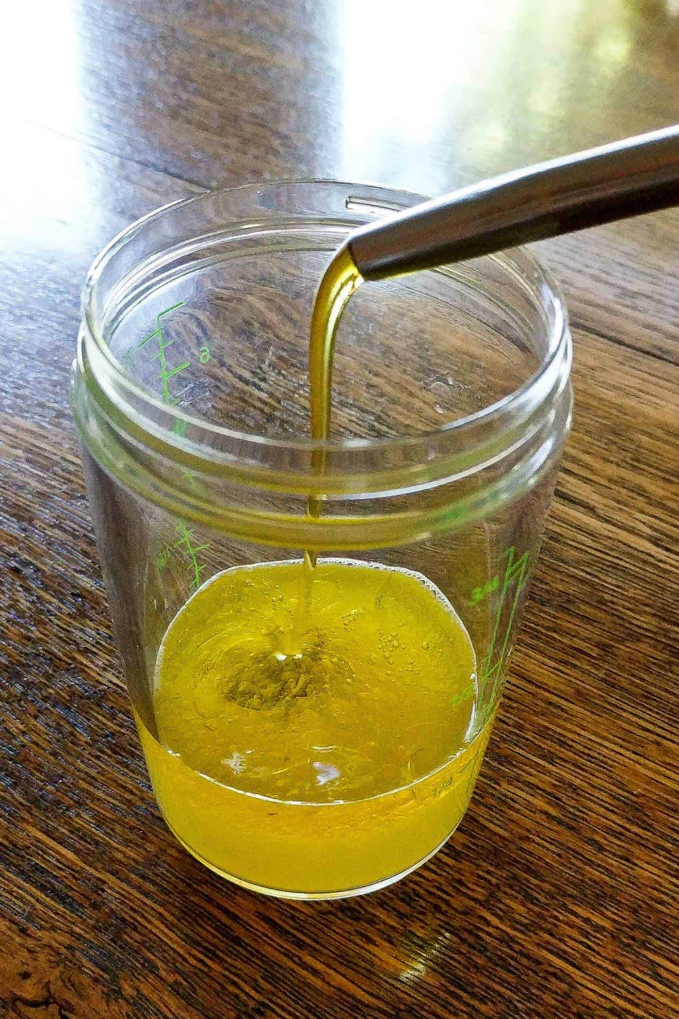 citrus dressing being poured into jar.