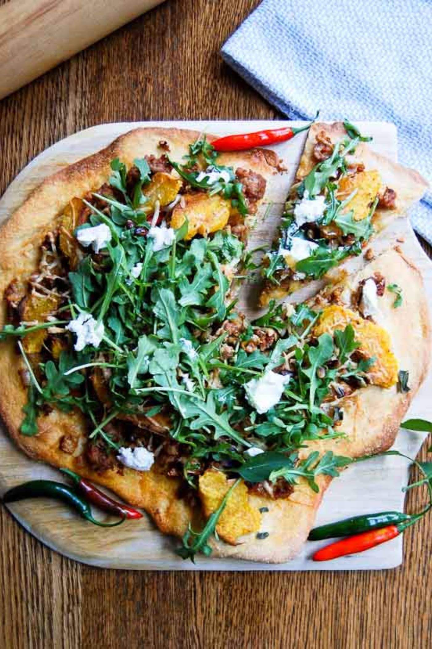 fall harvest pizza on cutting board.