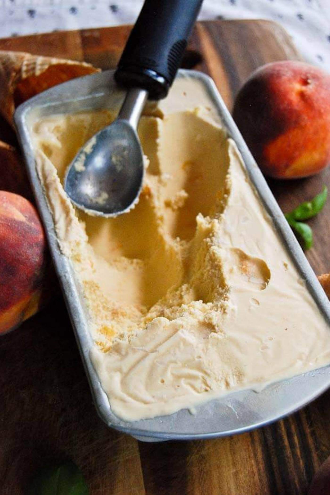 Peach Ice cream in pan with scoop.