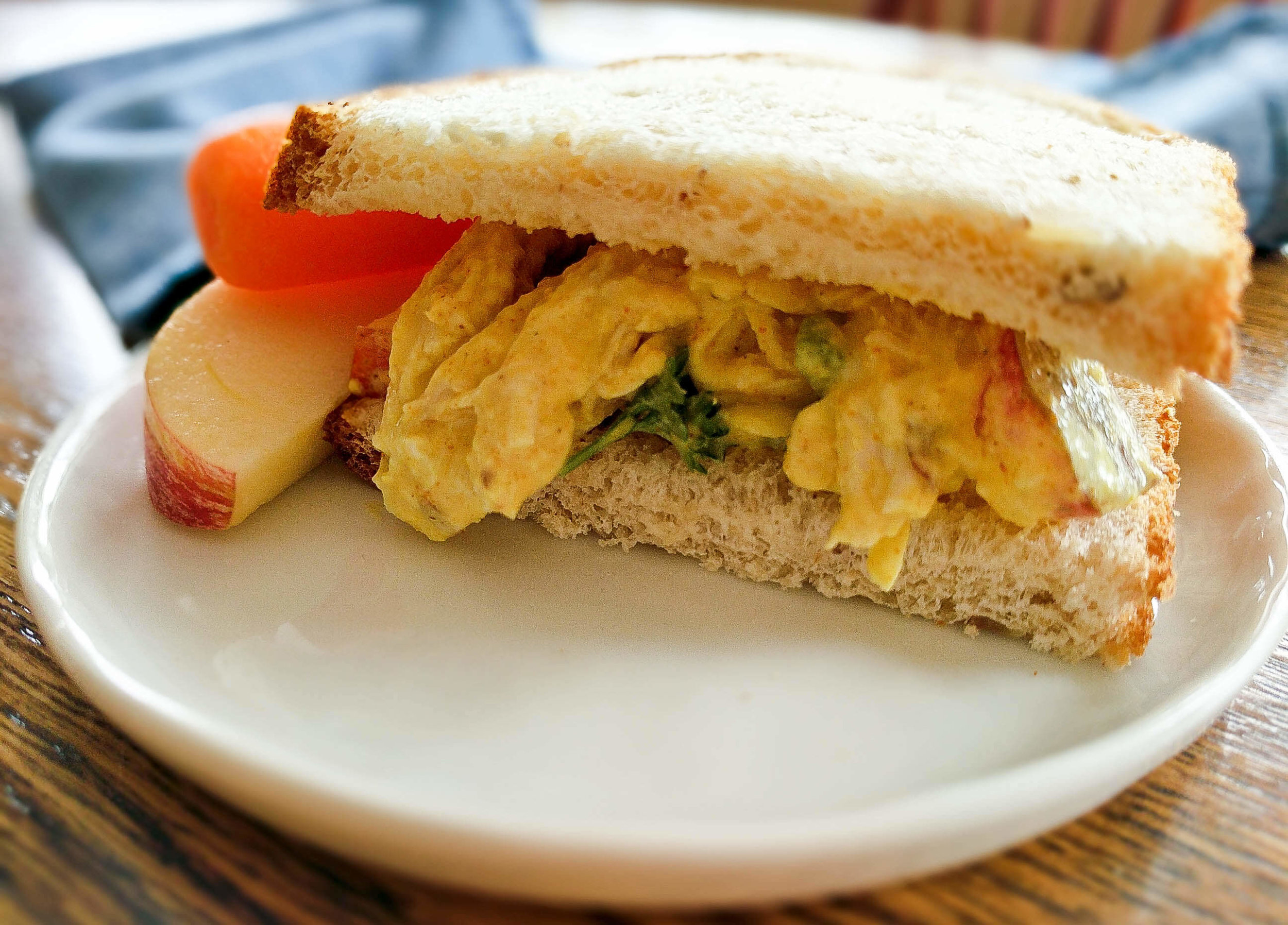 curried chicken salad sandwich on plate.