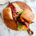 salmon blt sandwiches on cutting board.