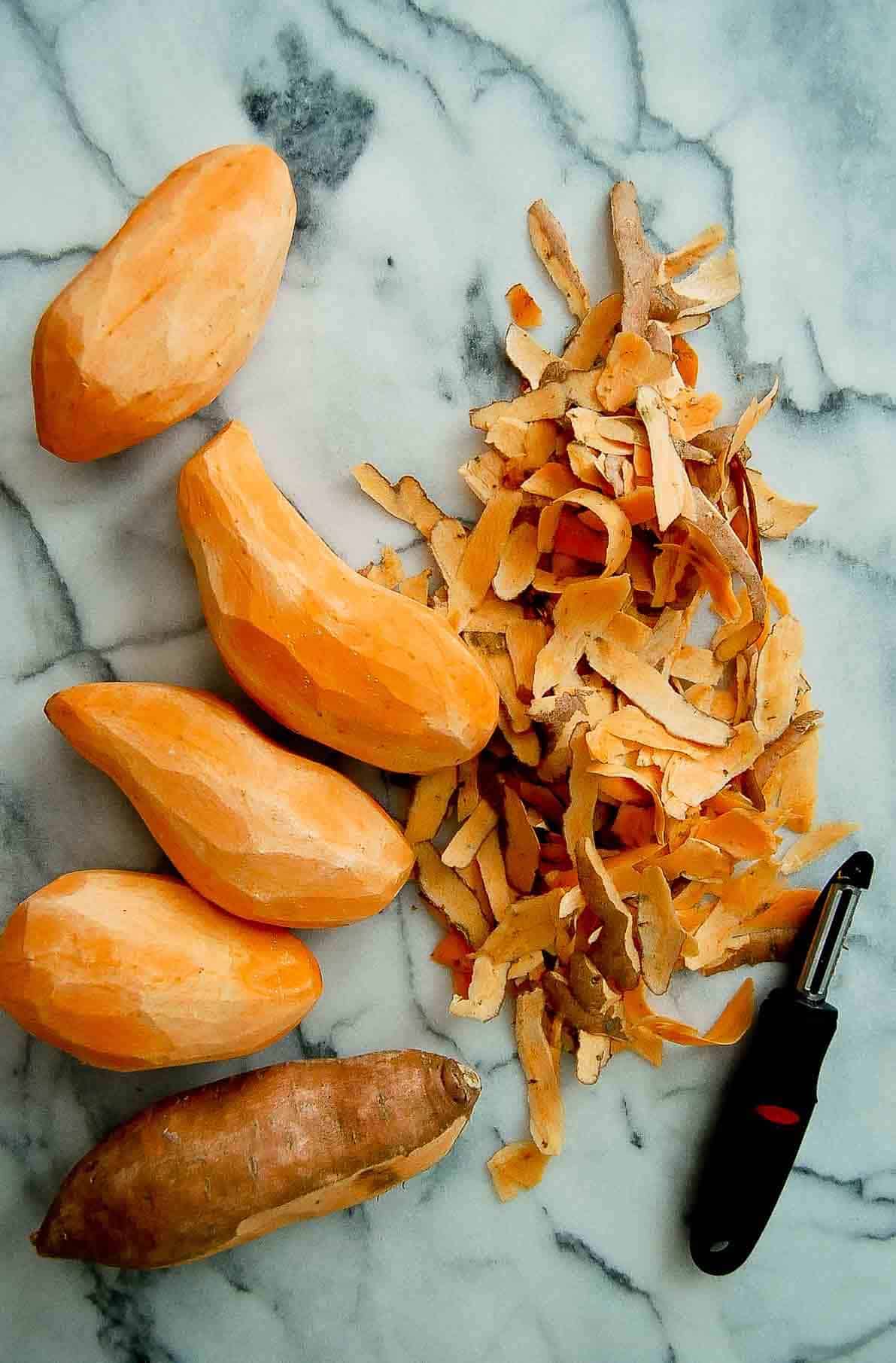 peeled sweet potatoes on marble counter.