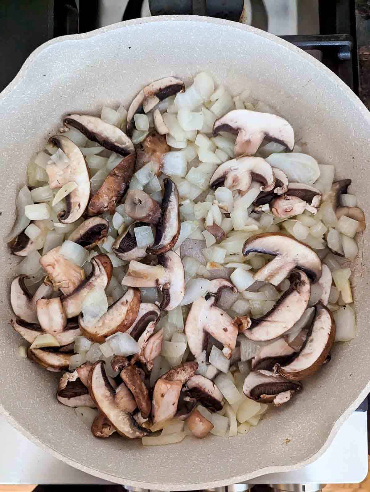 onion and mushrooms in pan.