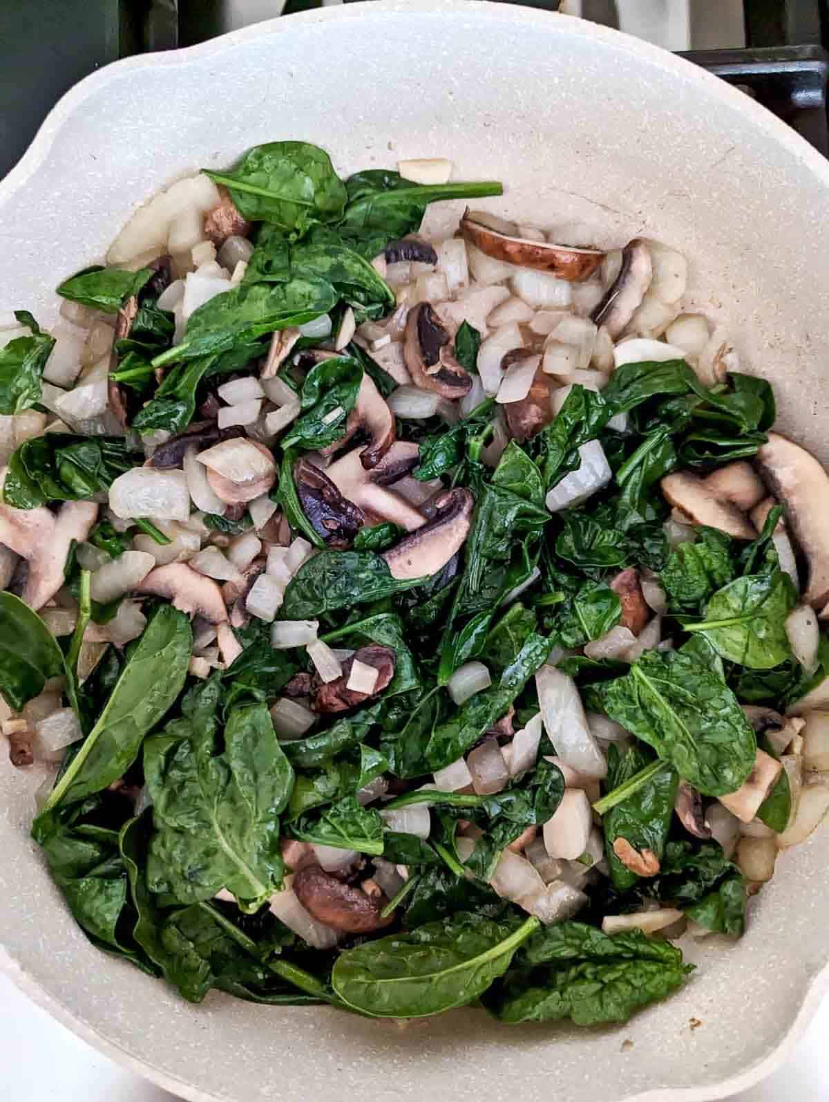 onion, mushrooms, spinach and garlic in pan.