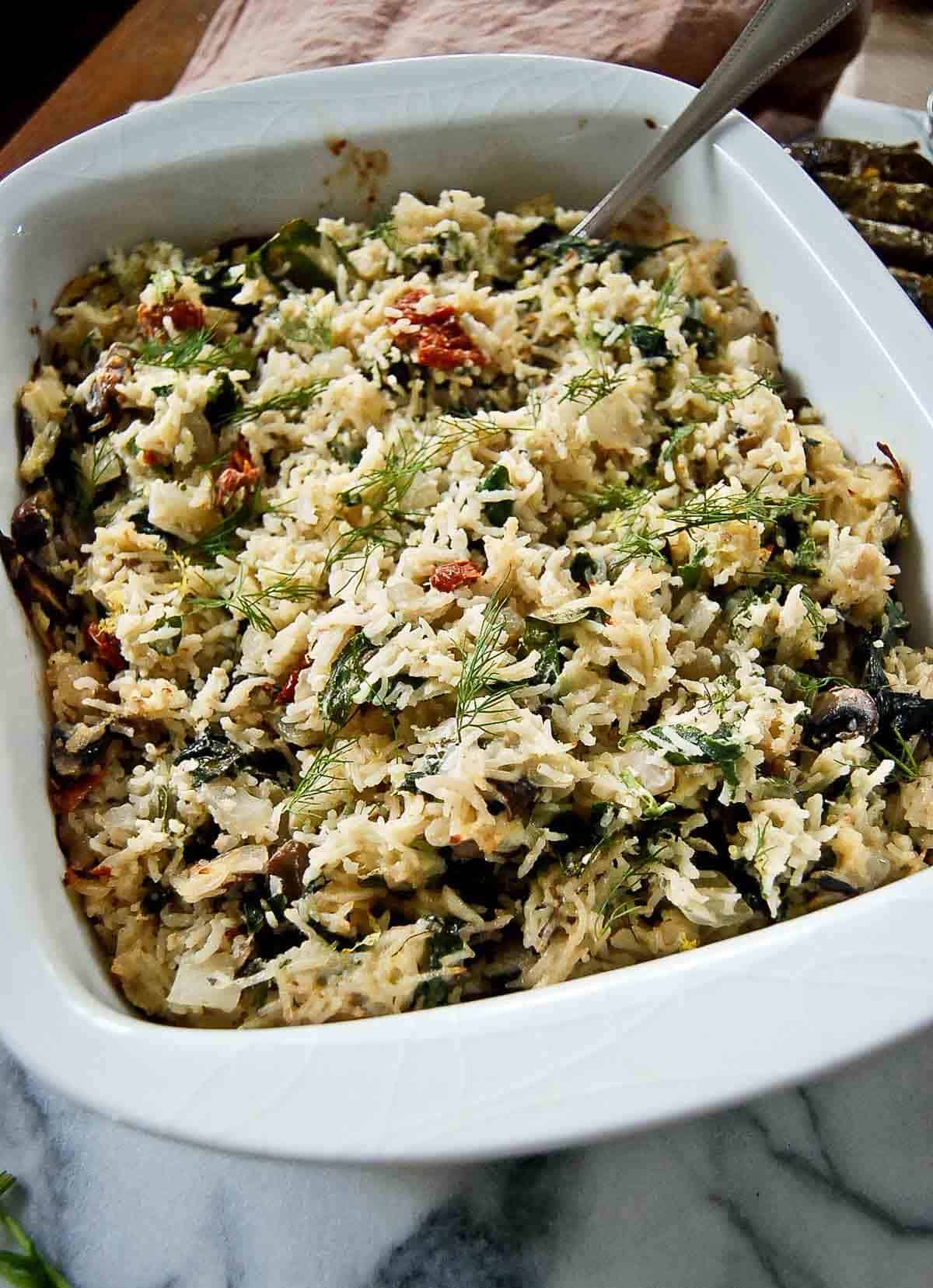close up side view of spinach feta and rice casserole in serving dish.