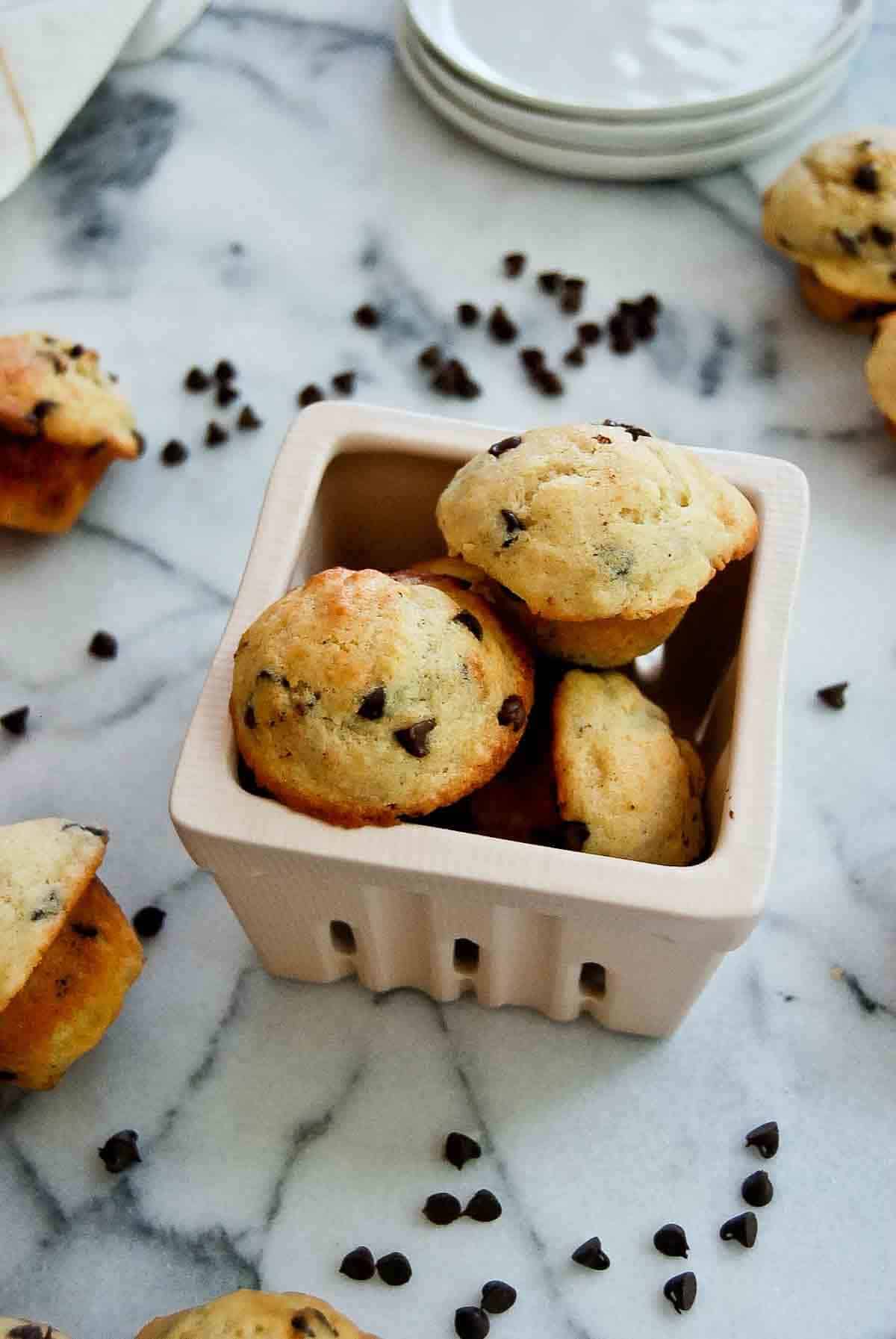 side view of chocolate chip mini muffins with yogurt on countertop.