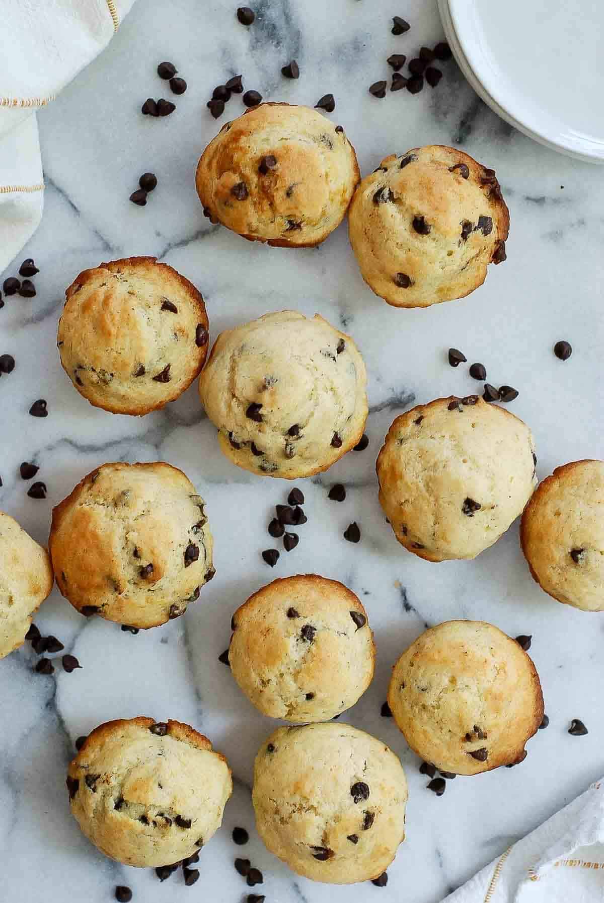 chocolate chip mini muffins with yogurt on countertop.