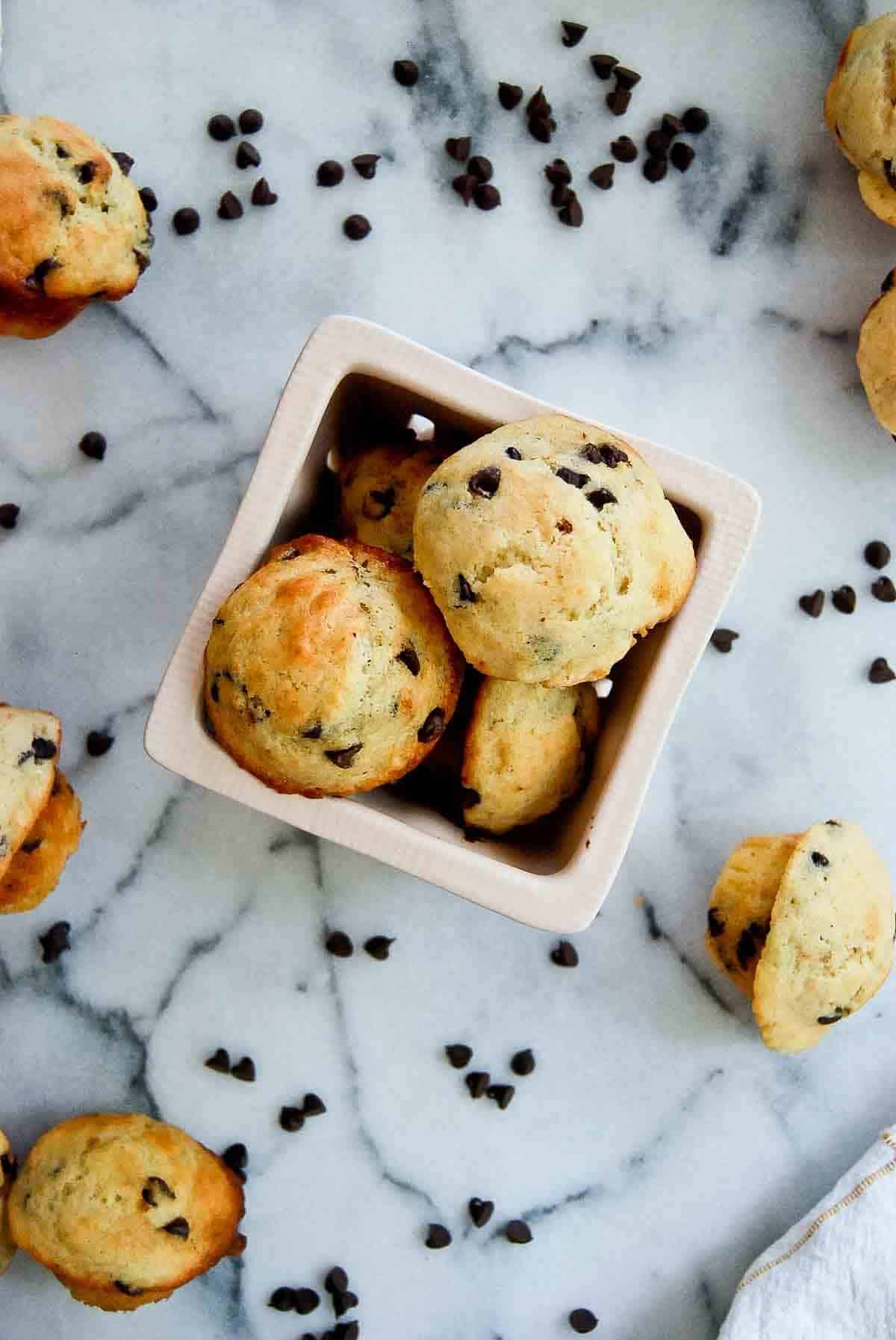 close up of chocolate chip mini muffins with yogurt in bowl.