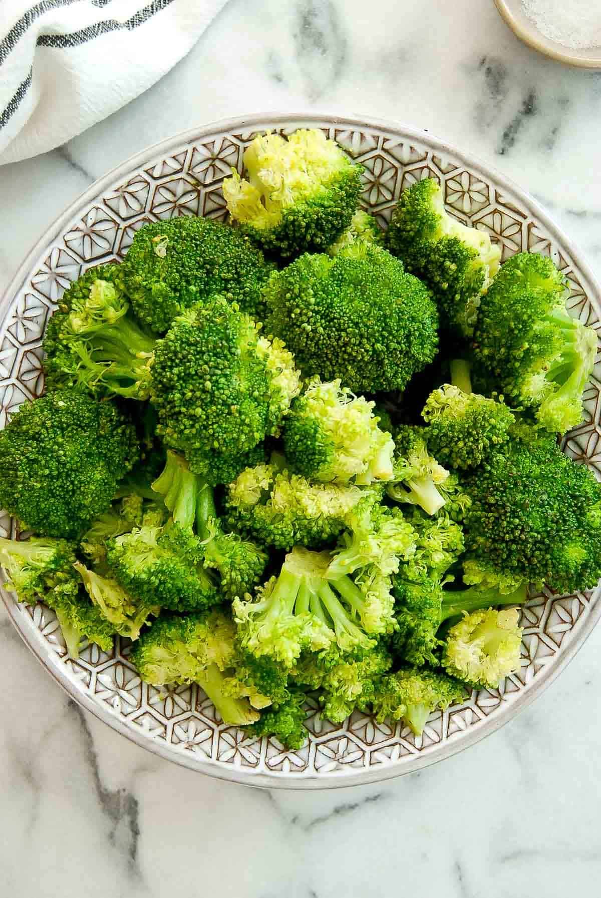 closeup of perfectly steamed broccoli in serving bowl.