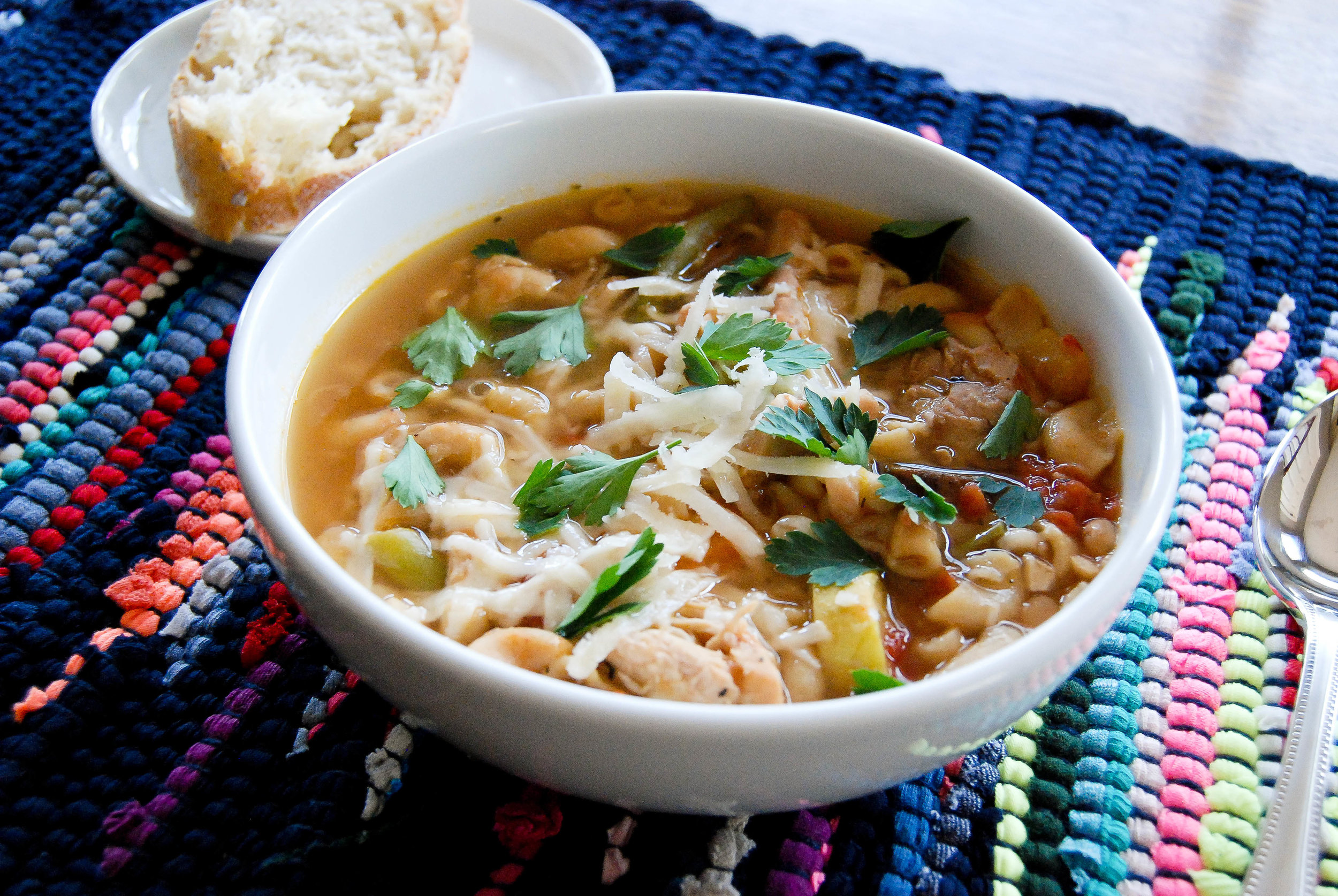 chicken minestrone soup in bowl on colorful placement.