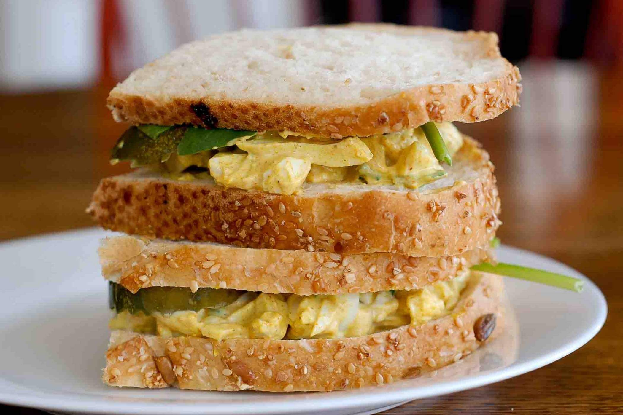 Egg salad sandwich, stacked on plate.