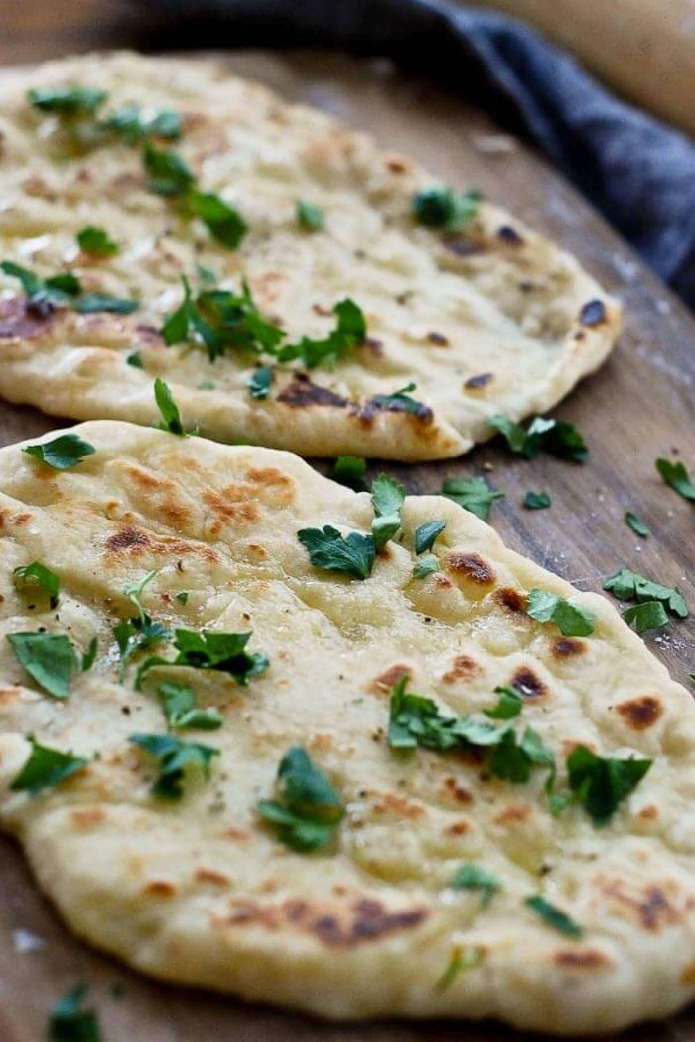 yogurt flatbread with parsley on cutting board.