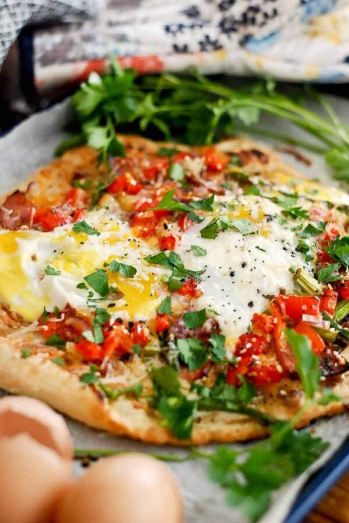 close up of breakfast pizza with egg.