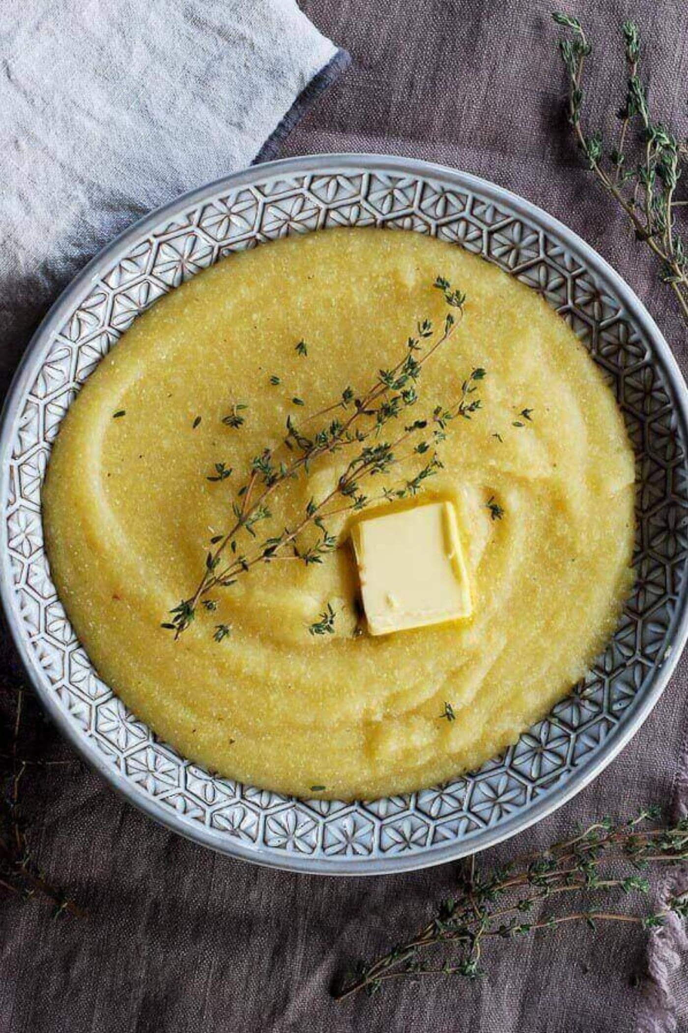 polenta in bowl with rosemary and butter.