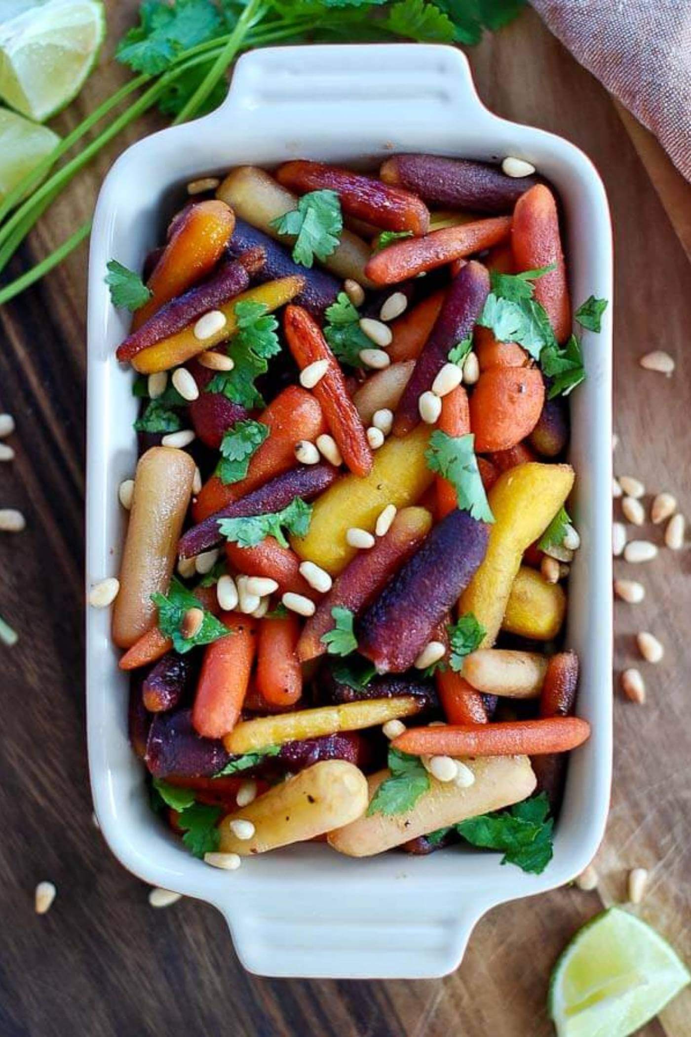 hot honey roasted carrots with pine nuts in casserole dish.