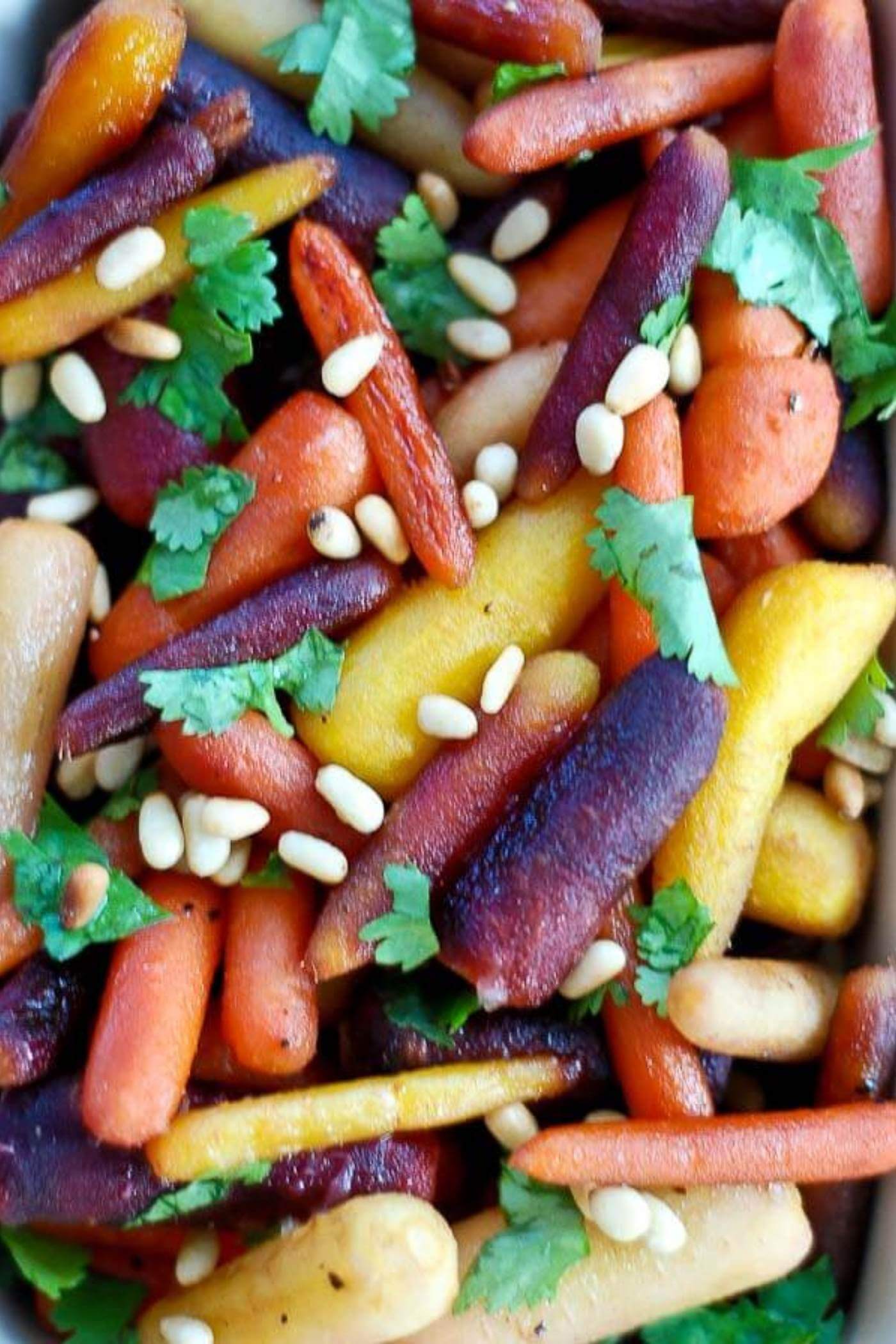 hot honey roasted carrots with pine nuts in casserole dish.