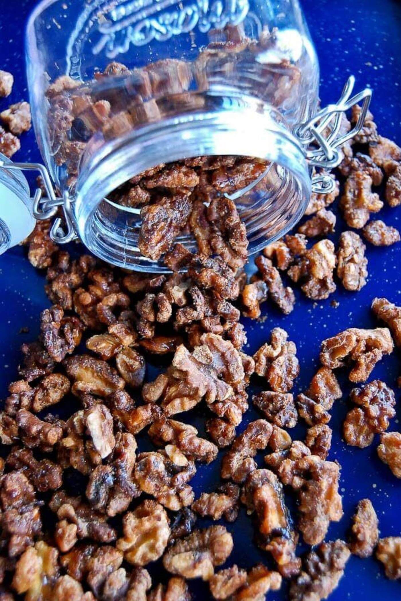 maple spiced roasted walnuts spilling from jar.