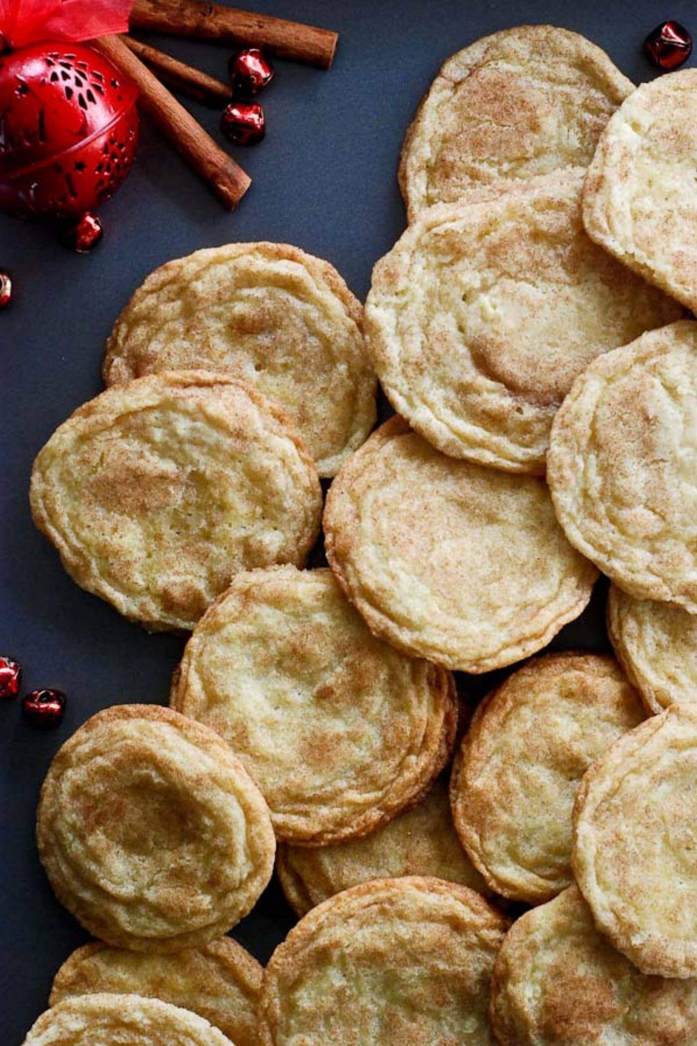 vanilla and maple snickerdoodle cookies on tray with cinnamon sticks.