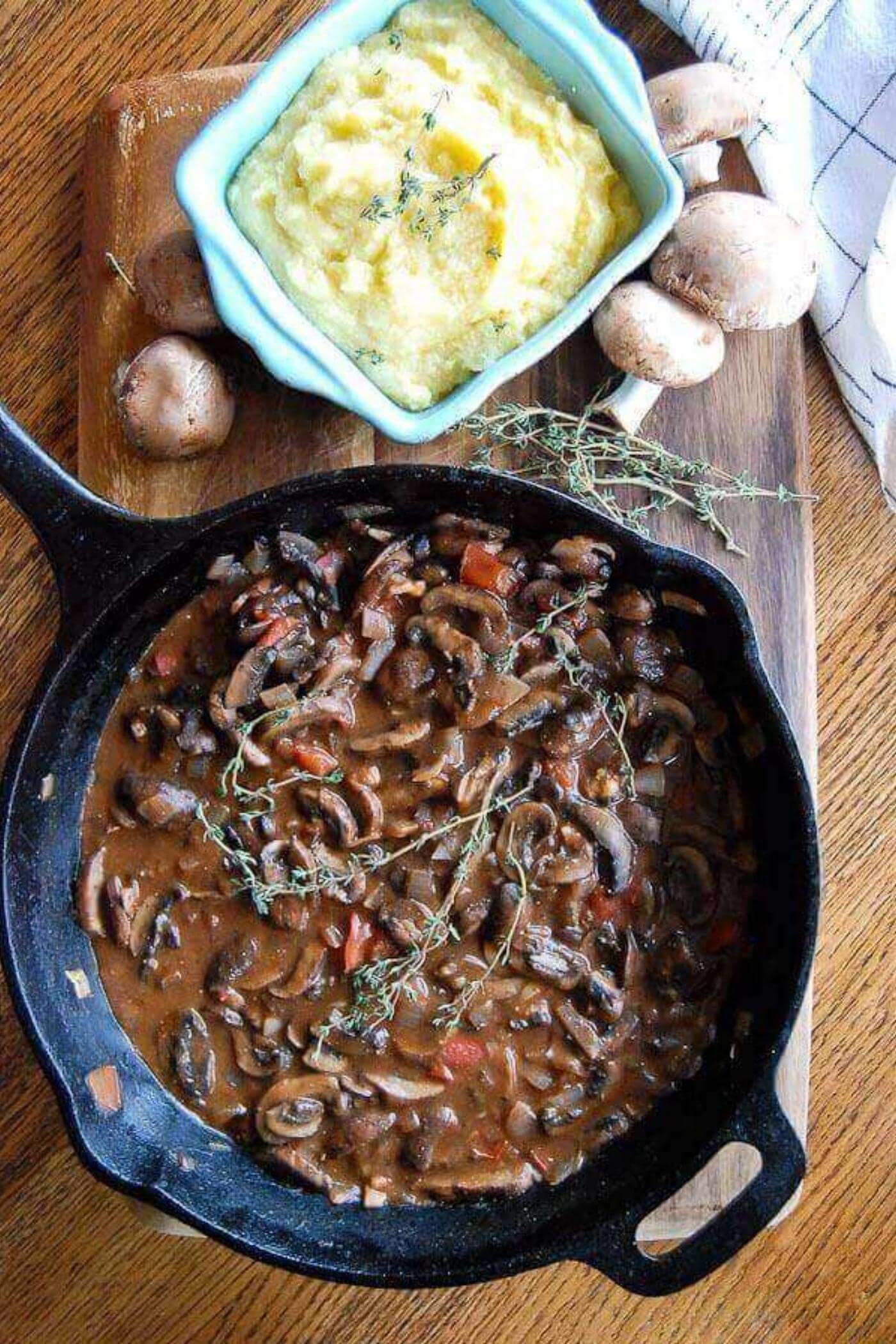 mushroom ragout in pan with polenta on the side.