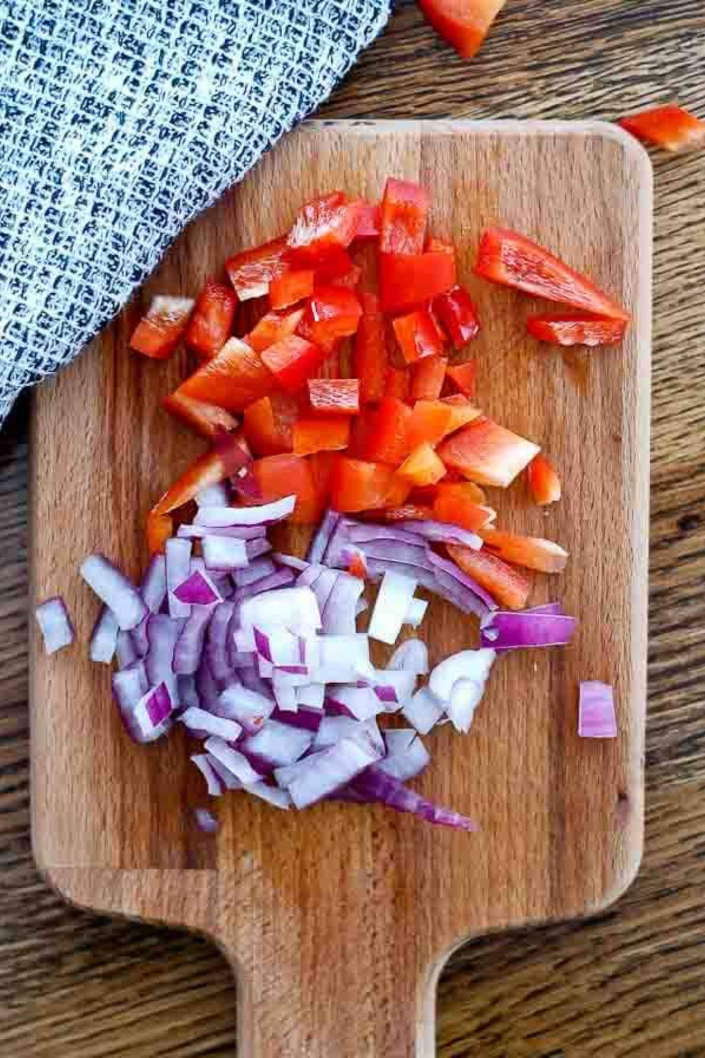 onion and red pepper, chopped on a cutting board.