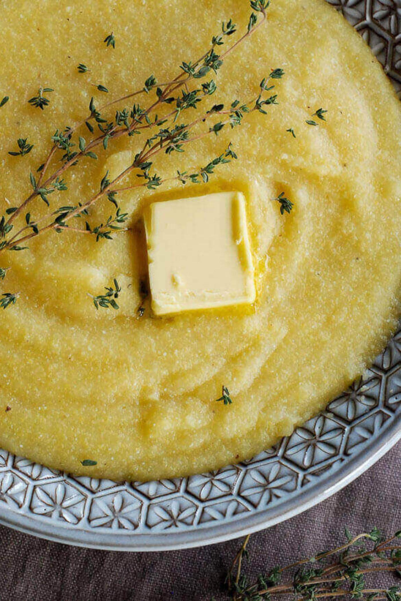 polenta in bowl with rosemary and butter.