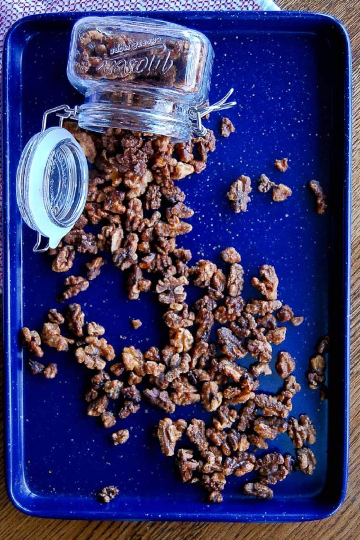 maple spiced roasted walnuts spilling from jar.