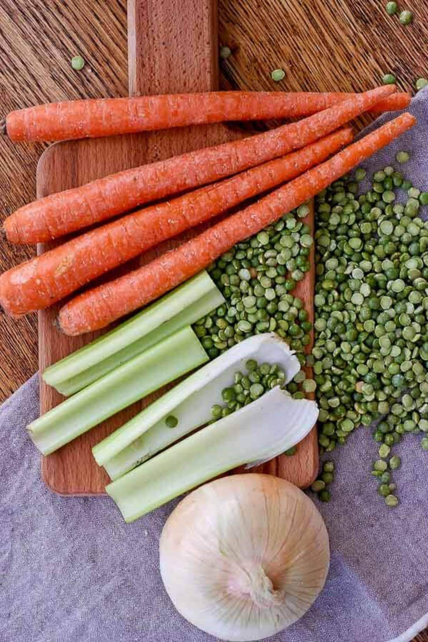carrots, celery, onion and split peas on table.