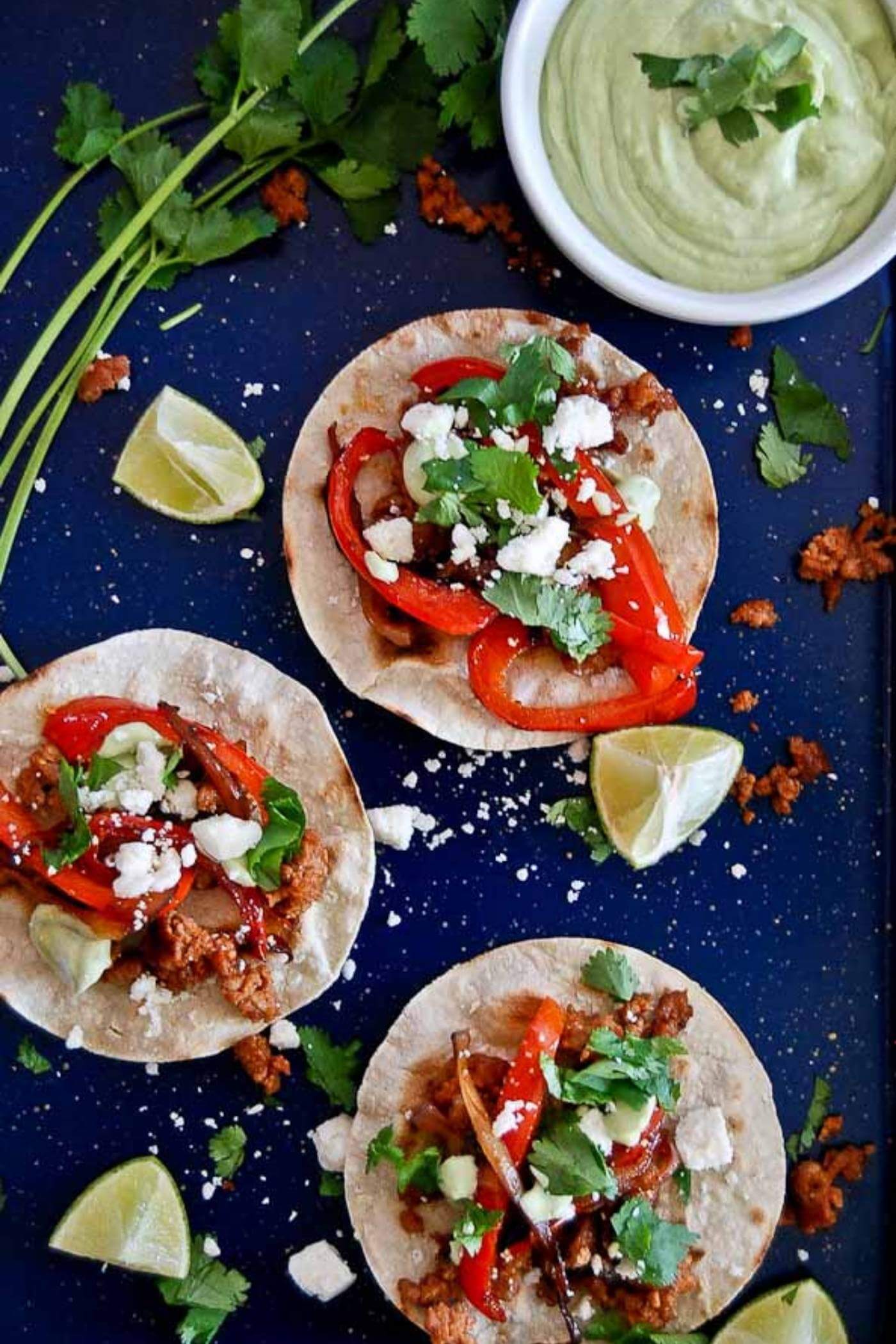 chorizo and red pepper tostadas on pan with avocado lime sauce.