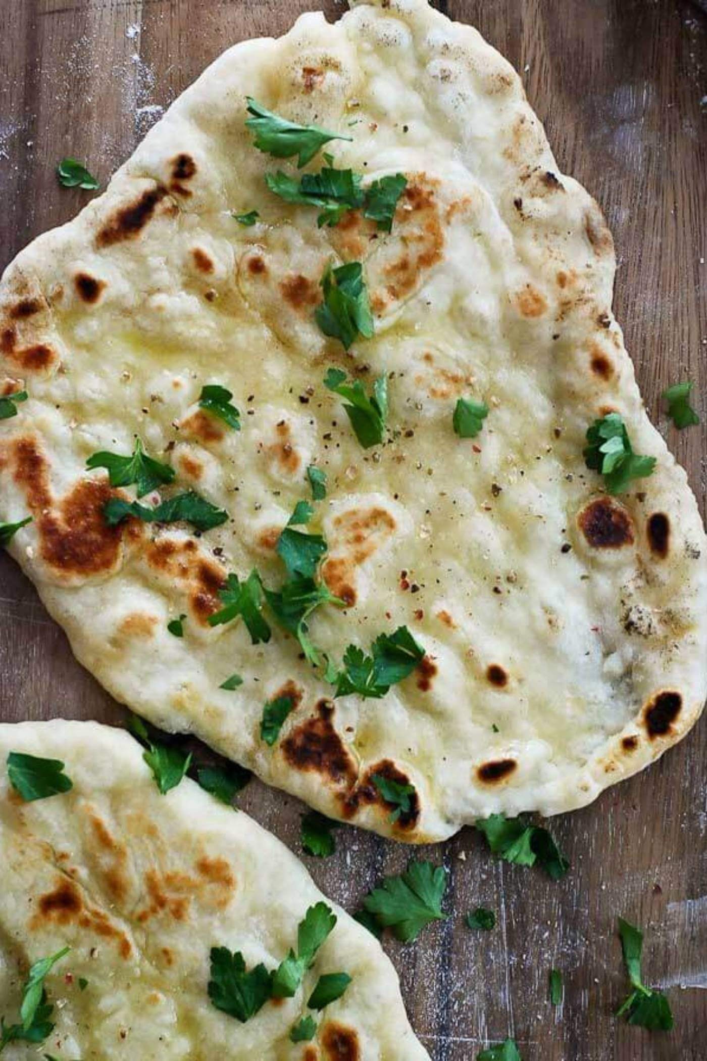 yogurt flatbread on cutting board with parsley.