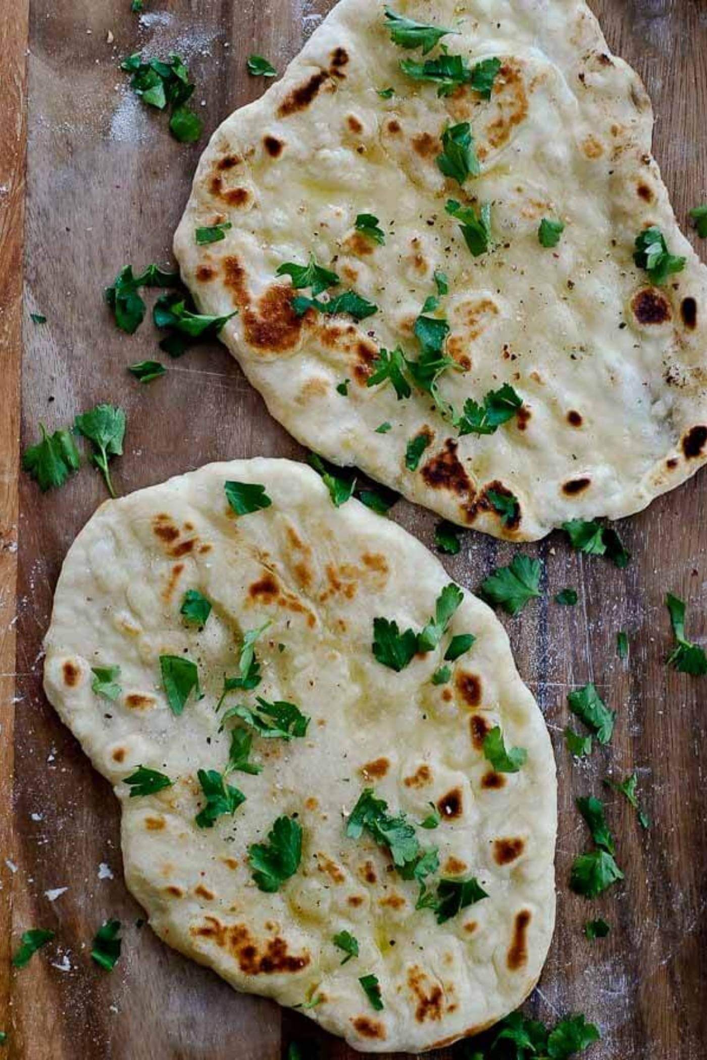 yogurt flatbread on cutting board with parsley.