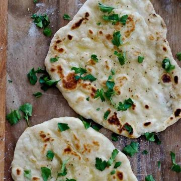 yogurt flatbread on cutting board with parsley