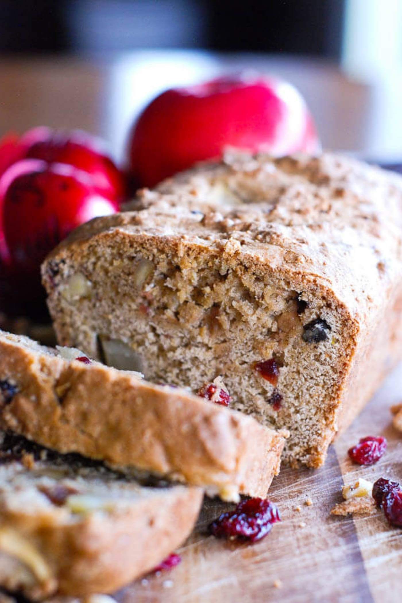 apple cranberry and walnut quick bread on cutting board.