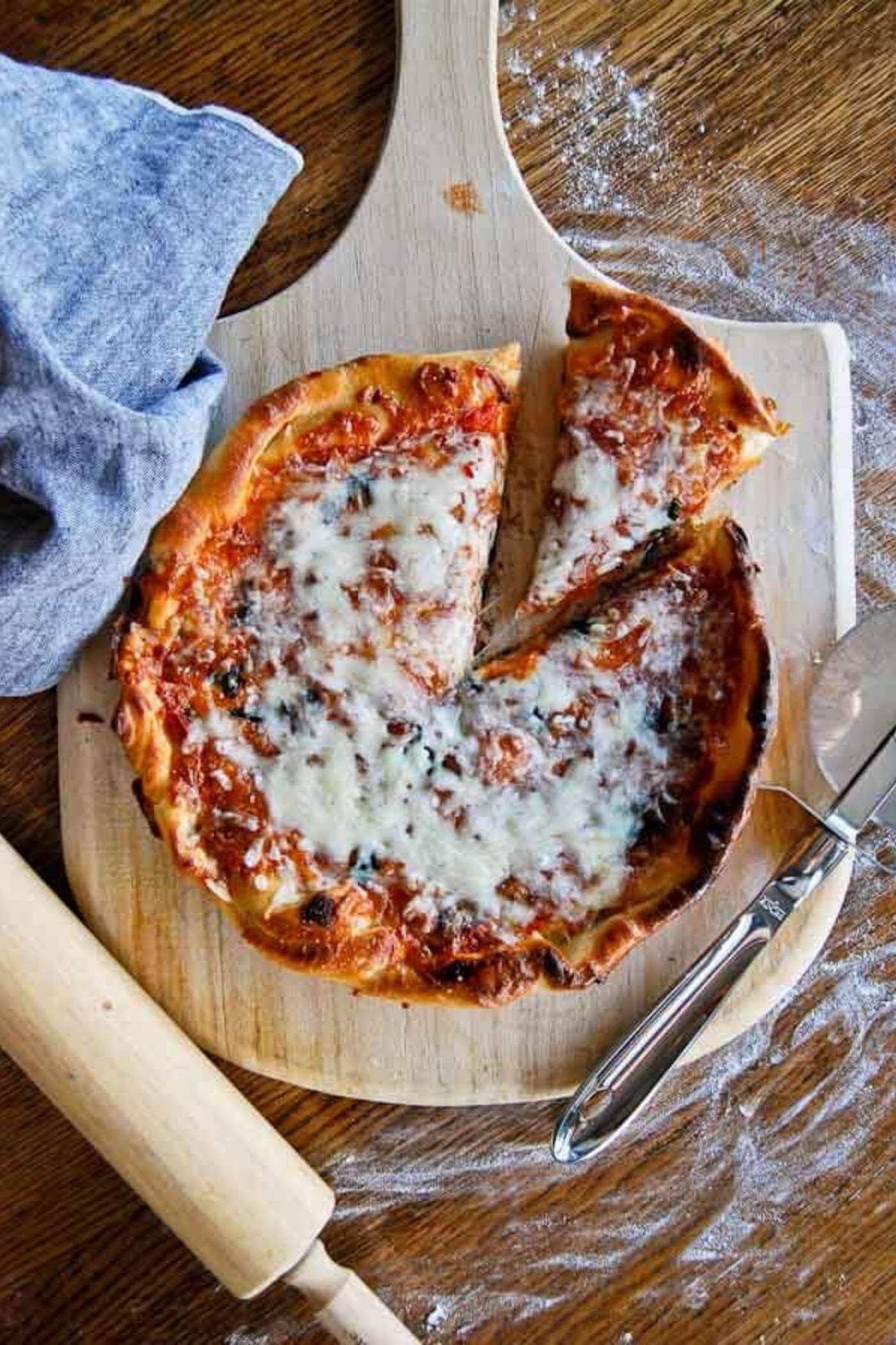 cast iron skillet pizza on cutting board with slice cut out.