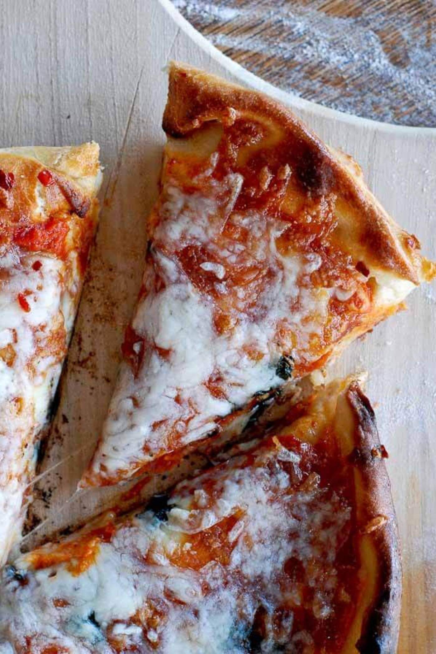 slice of pizza on cutting board.