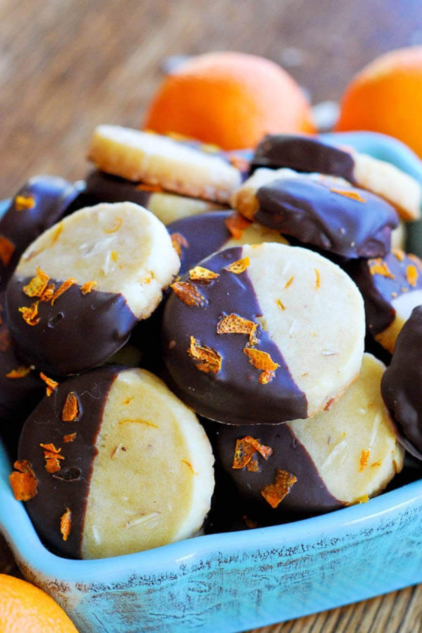 chocolate dipped orange and almond shortbread cookies in bowl.