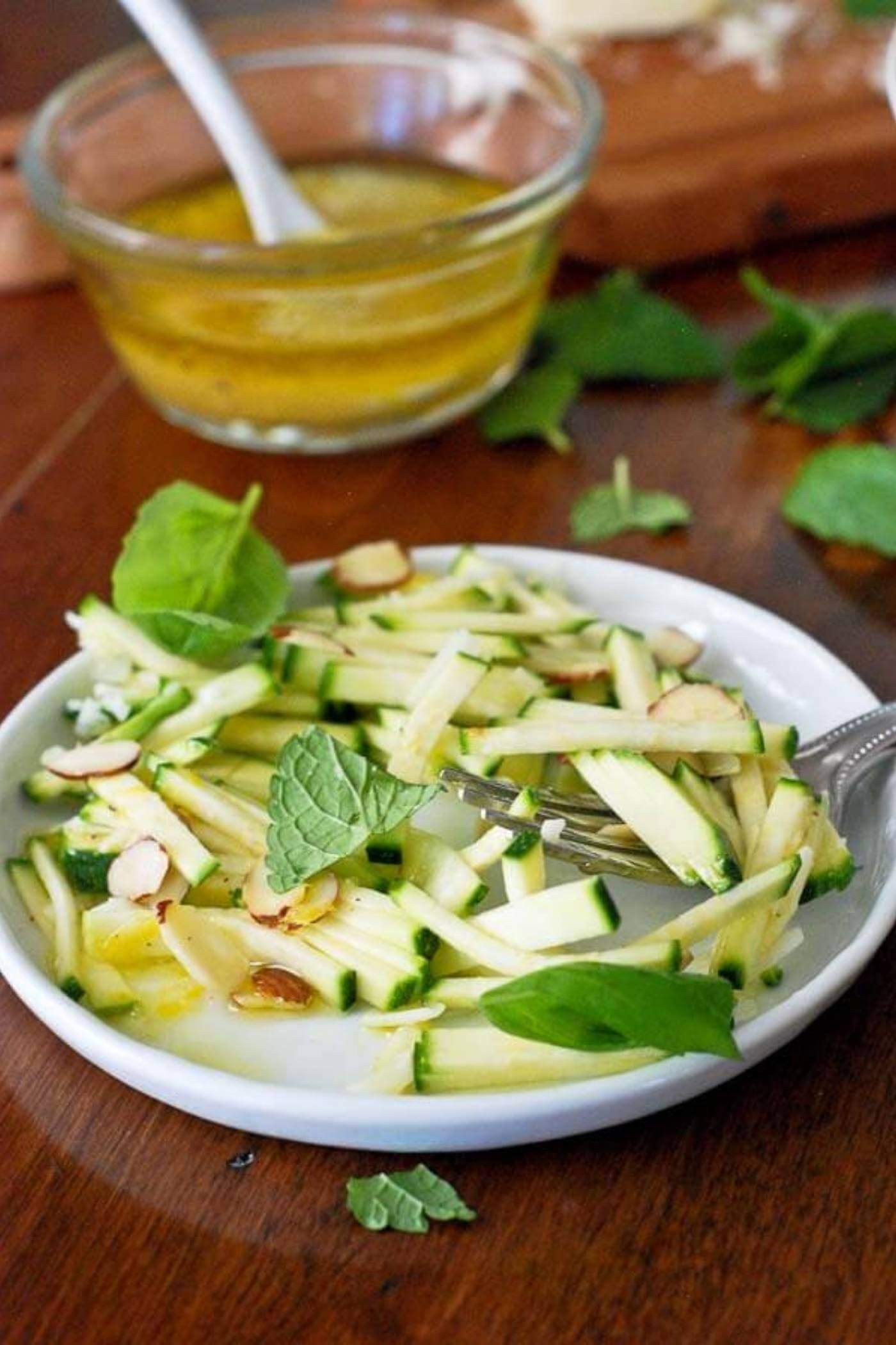 chopped zucchini and herb salad with parmesan on plate.