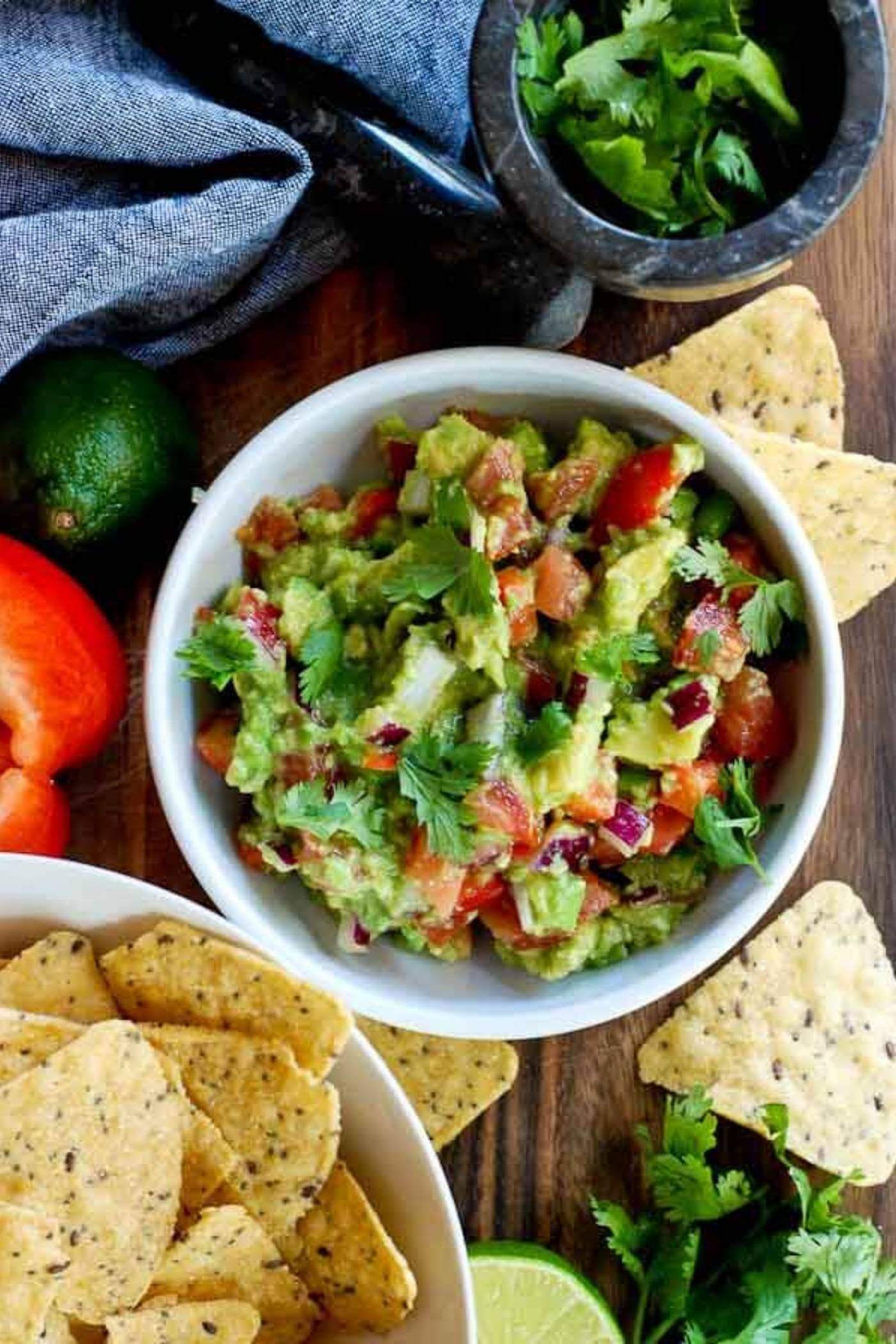 chunky guacamole in bowl with chips.
