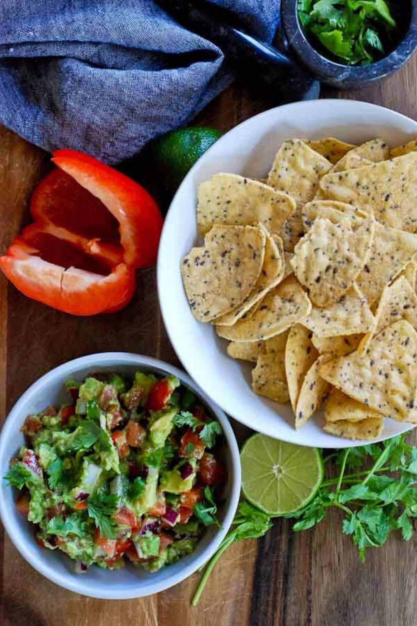 chunky guacamole with chips and ingredients.