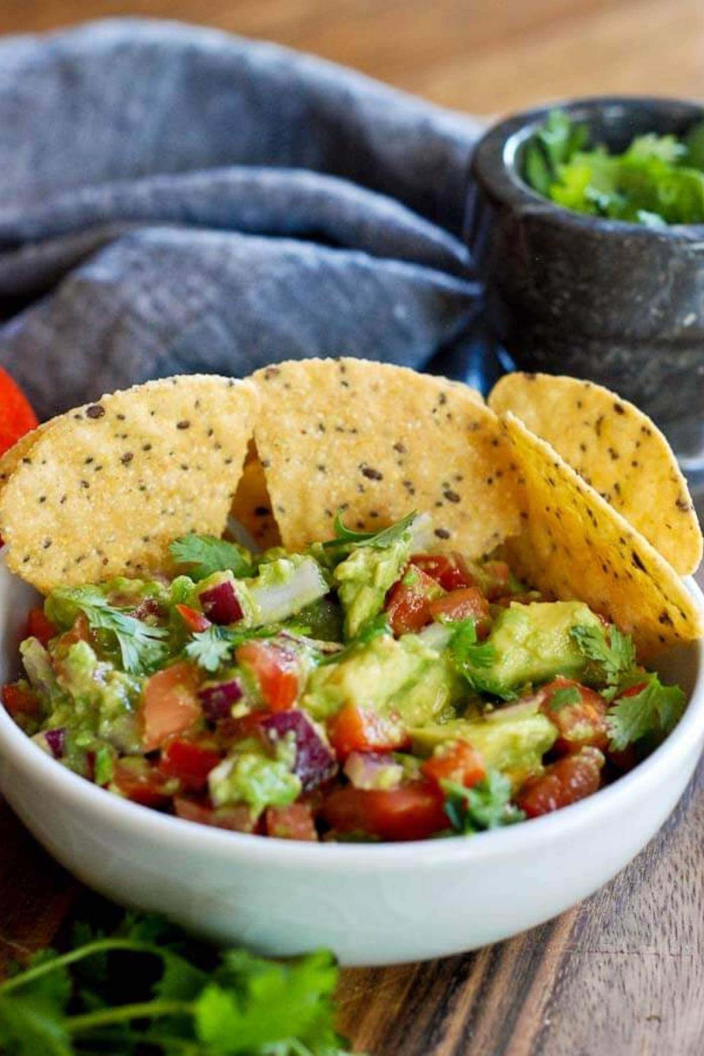 chunky guacamole in bowl with chips.