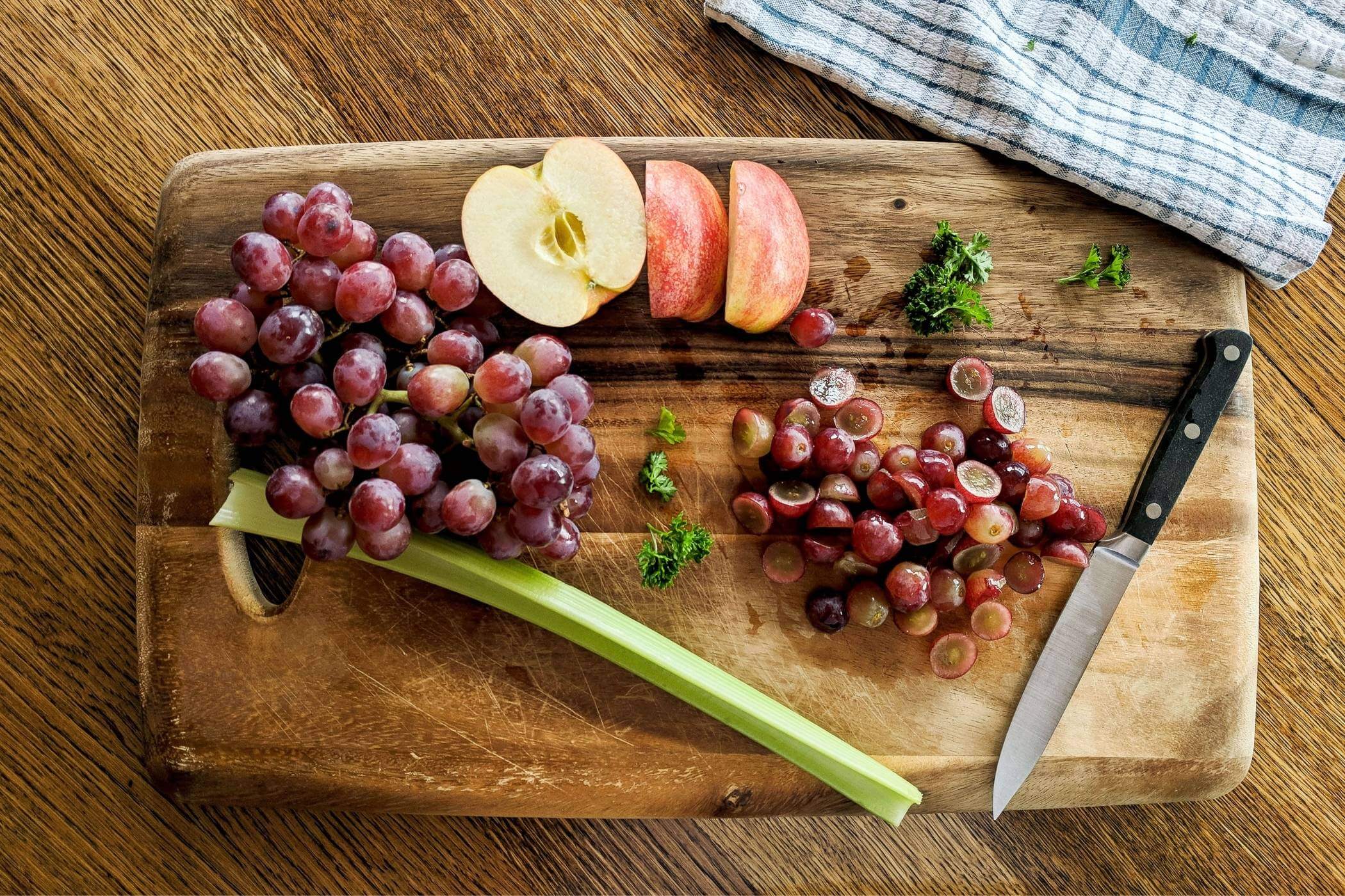 grapes and apples on cutting board.