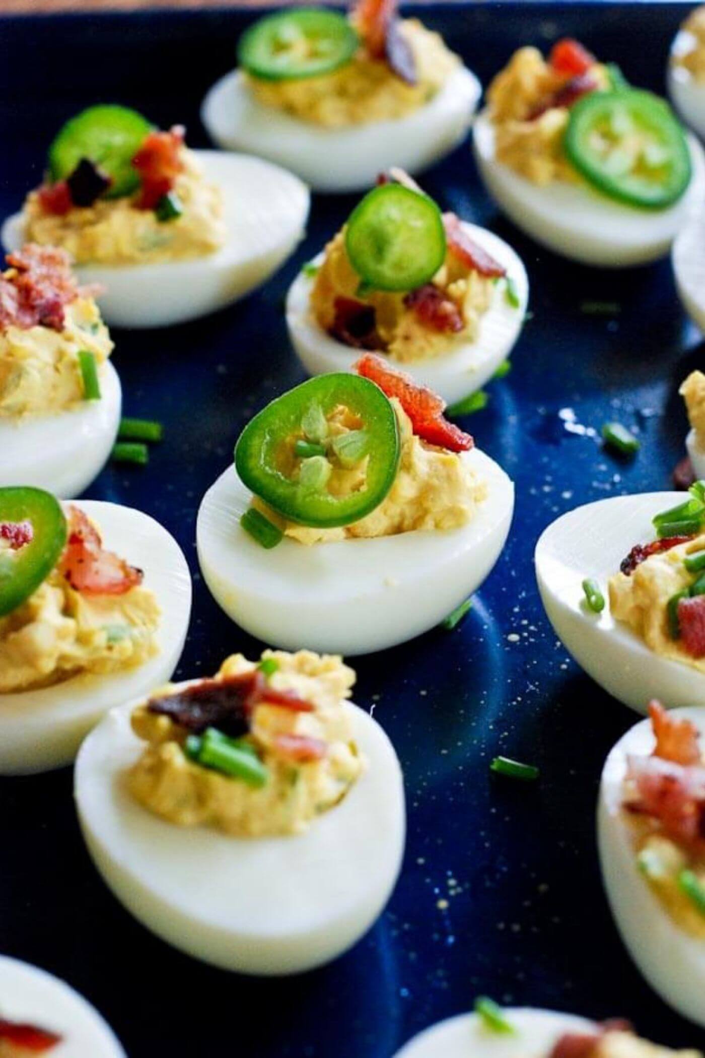 deviled eggs with bacon and jalapeno on tray.