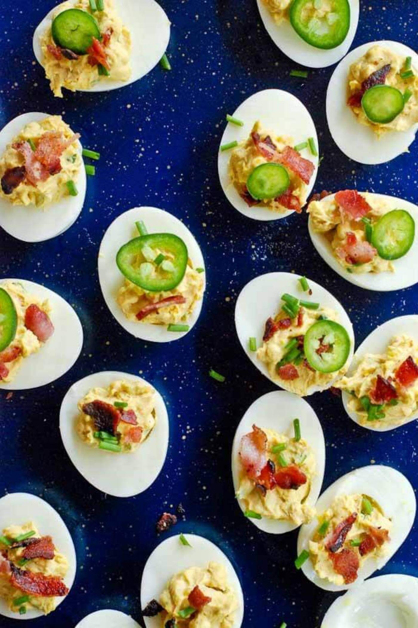 deviled eggs with bacon and jalapeno on tray.