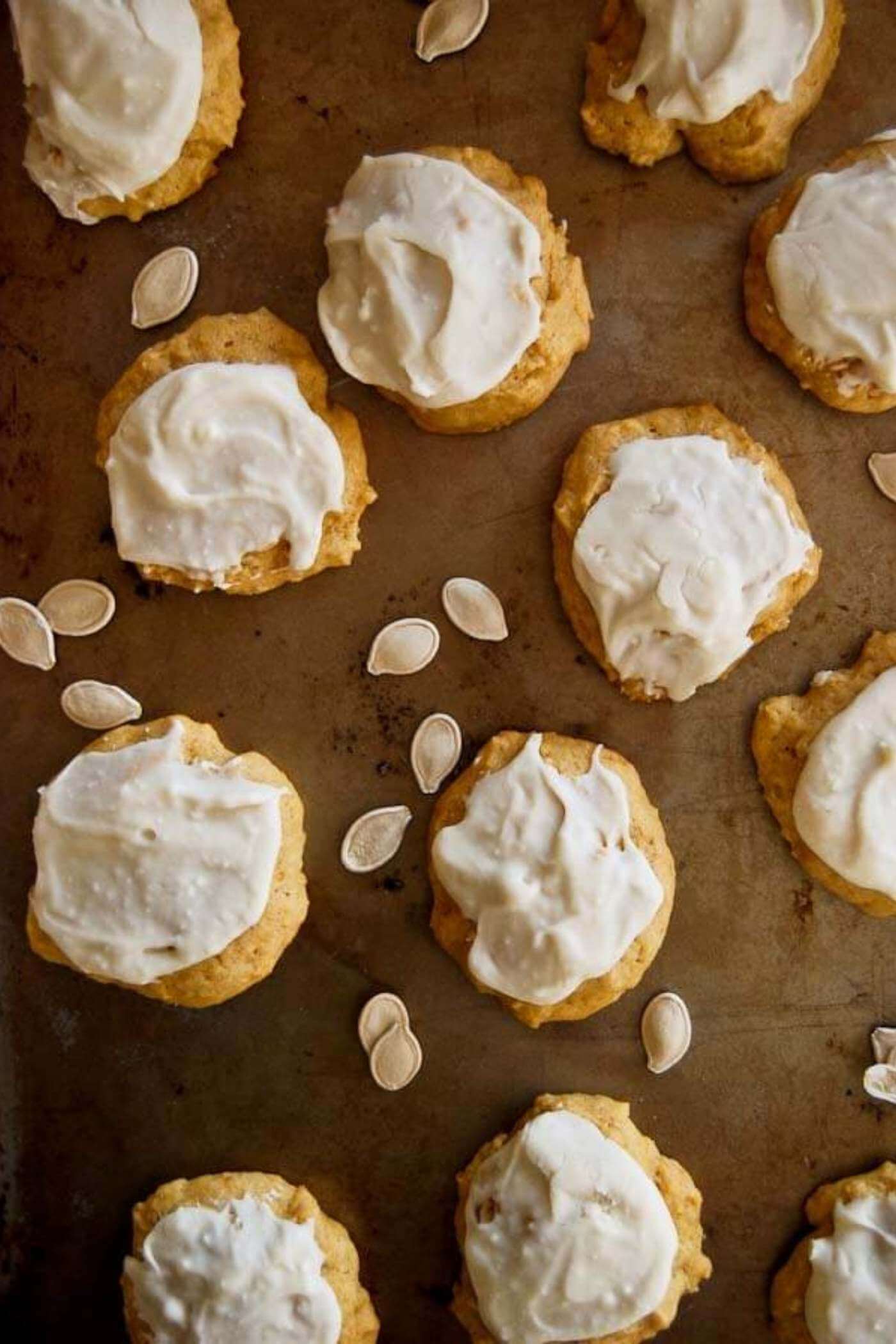 soft pumpkin cookies with cream cheese icing on tray.