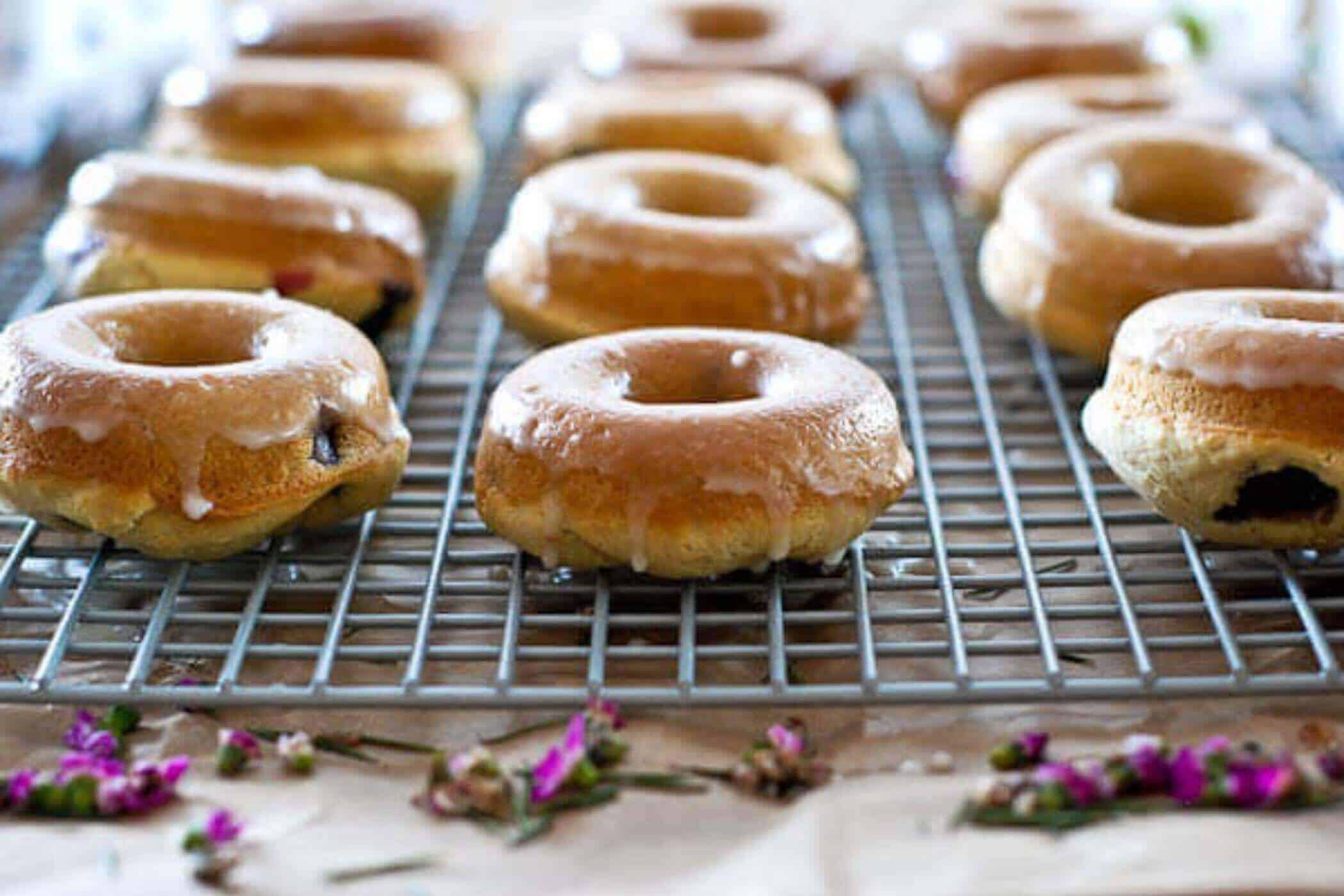 glazed lemon and blueberry baked donuts on cooling tray.