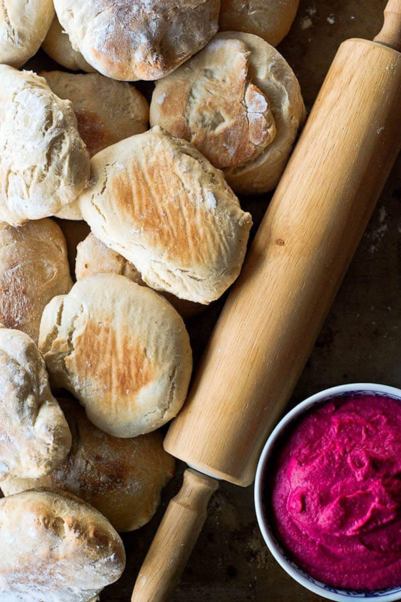 pita bread next to rolling pin and beet root hummus.