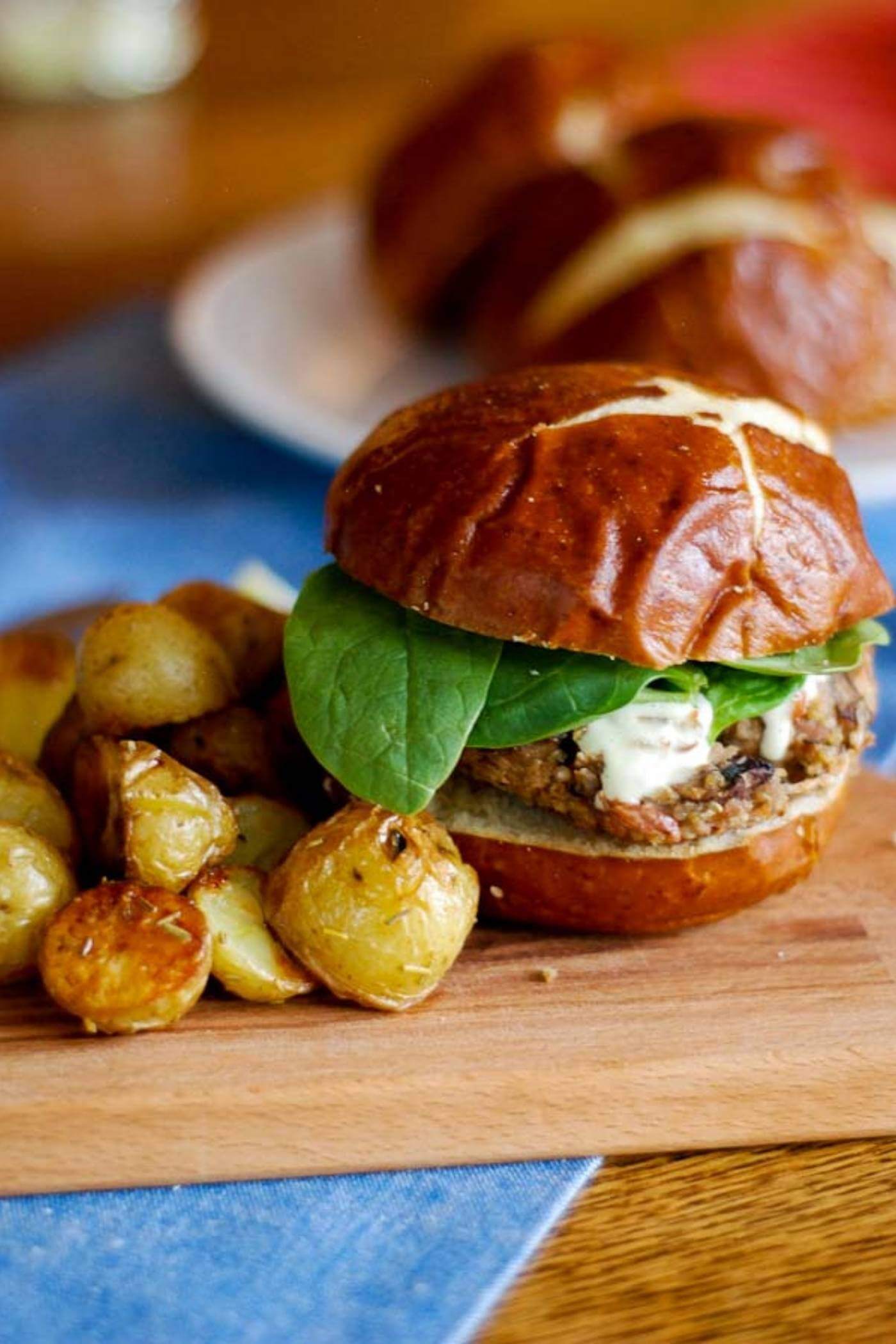 mushroom burger on cutting board with potatoes.