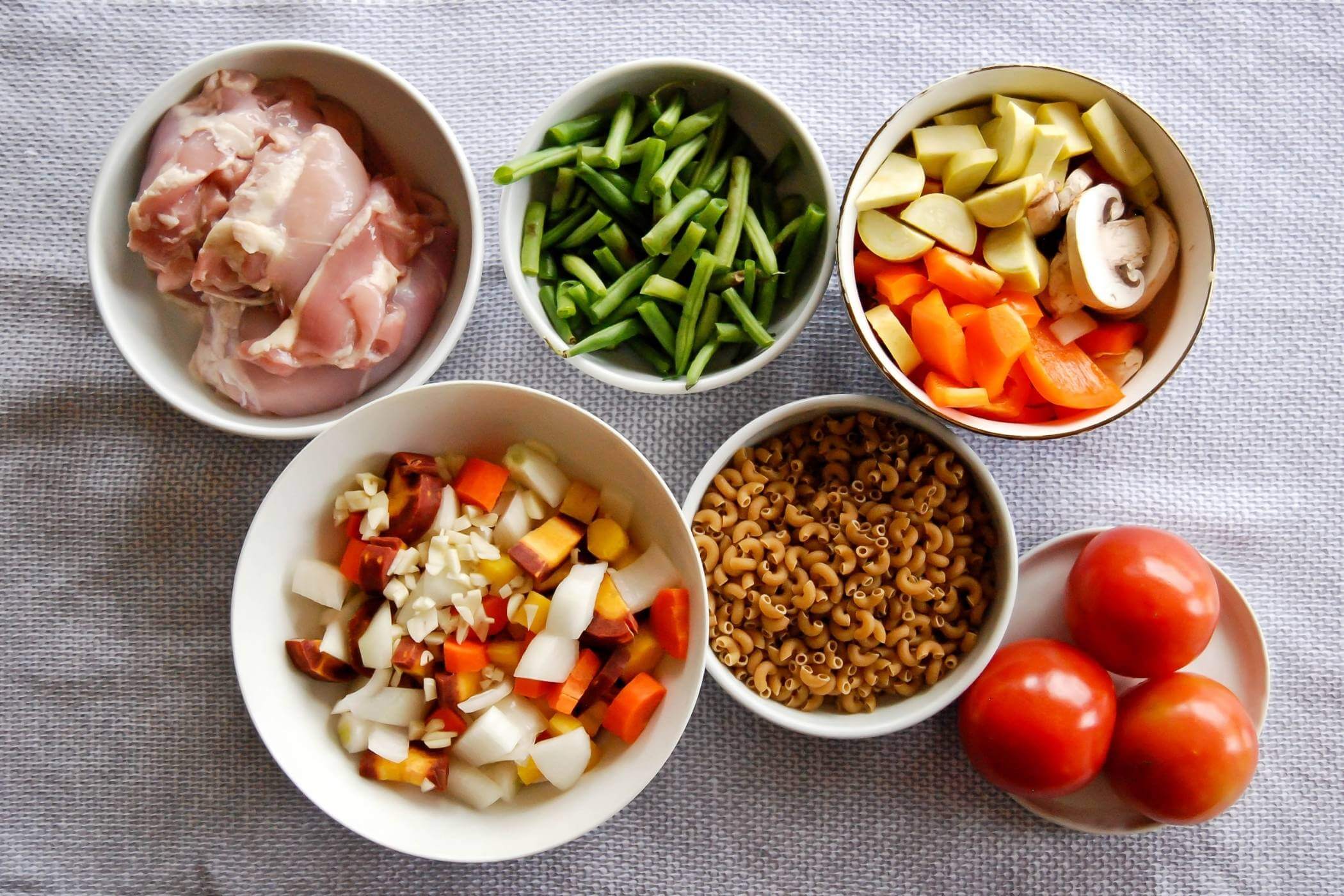 one pot chicken minestrone soup ingredients in bowls.