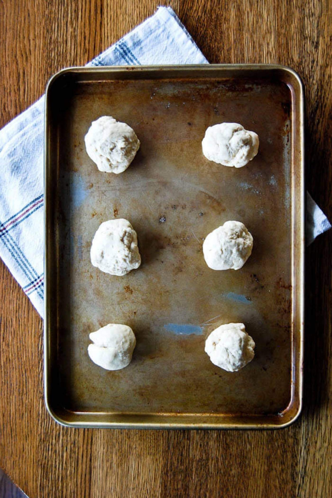 pita bread dough balls on baking sheet.