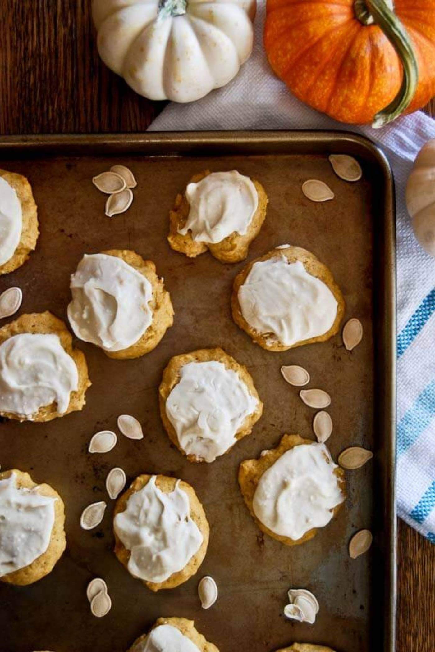 soft pumpkin cookies with cream cheese icing on tray.
